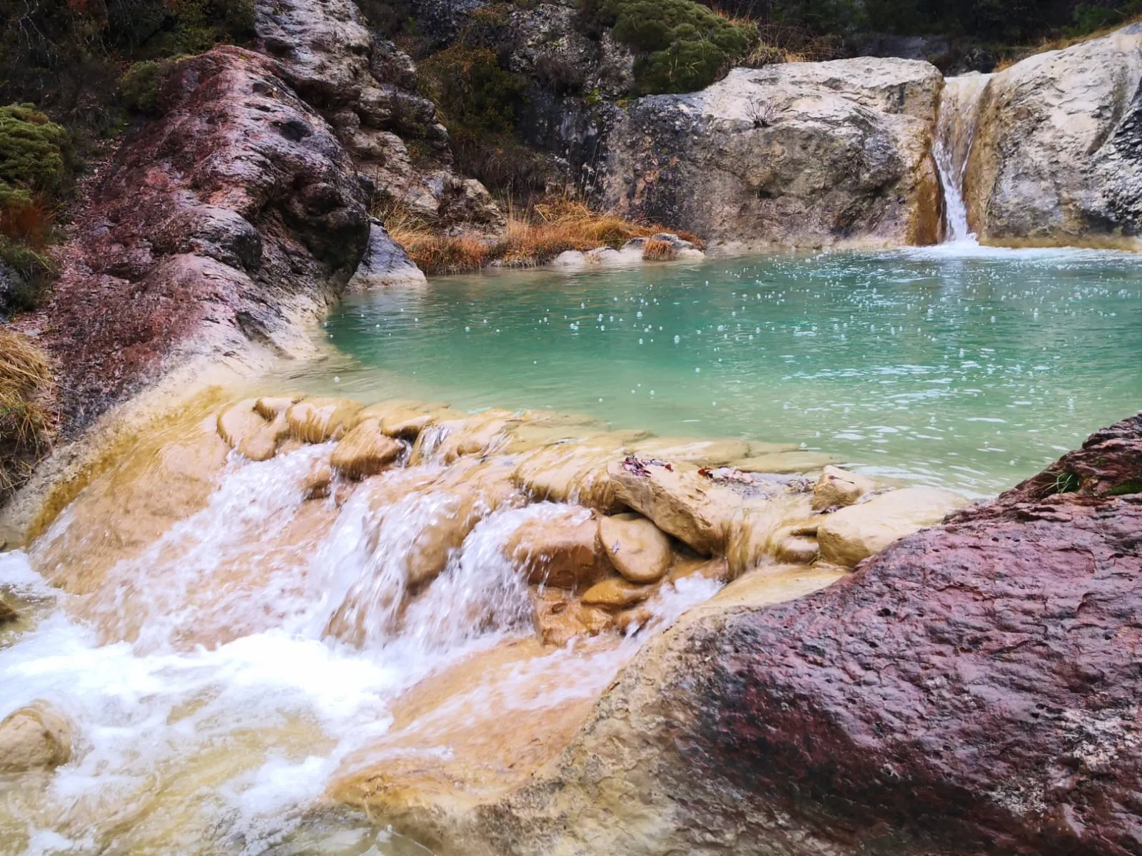 Poza natural con agua turquesa cerca de la casa rural en el Pirineo.