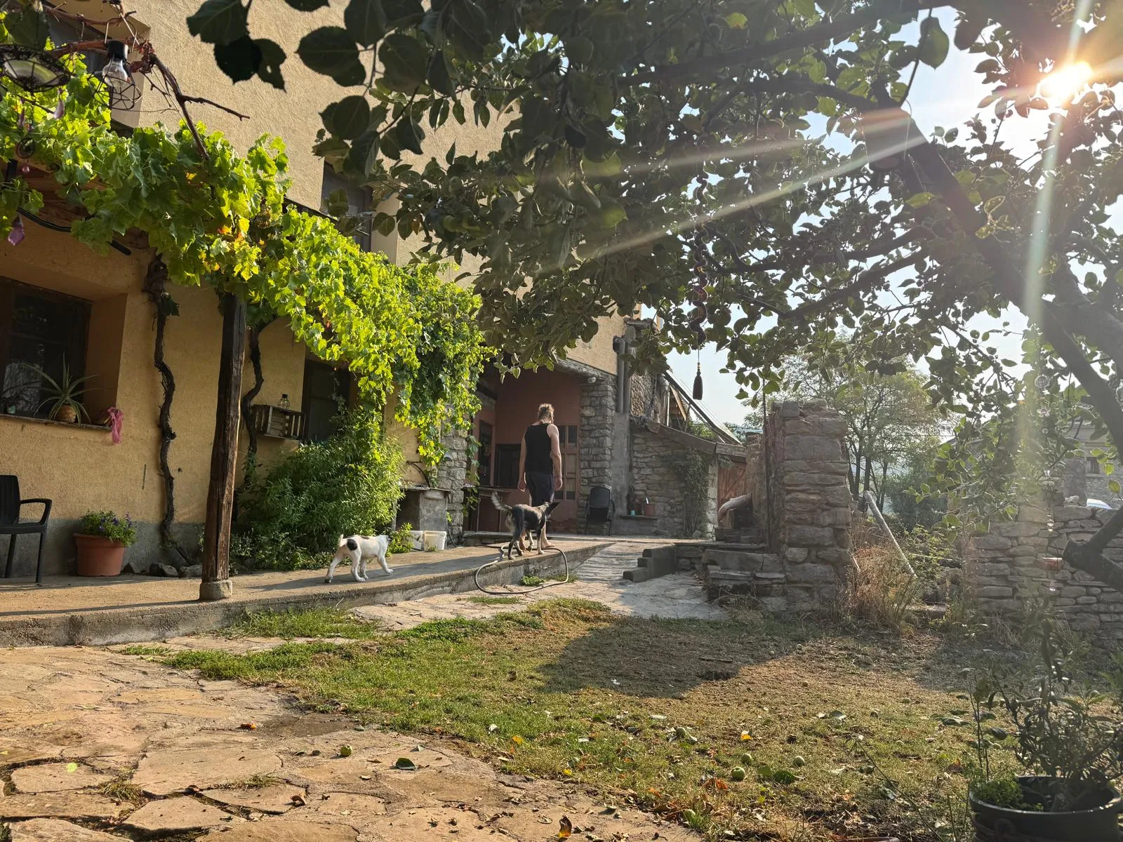 Fachada de Casa Rural Gillué en piedra con banco exterior, alojamiento rural en el Pirineo.