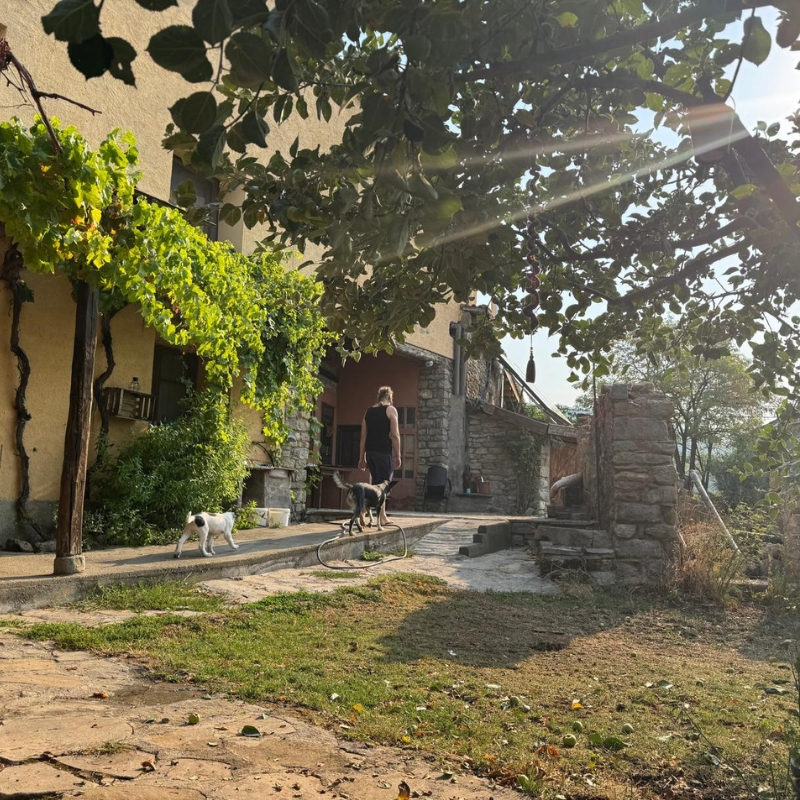 Fachada de Casa Rural Gillué en piedra con banco exterior, alojamiento rural en el Pirineo.
